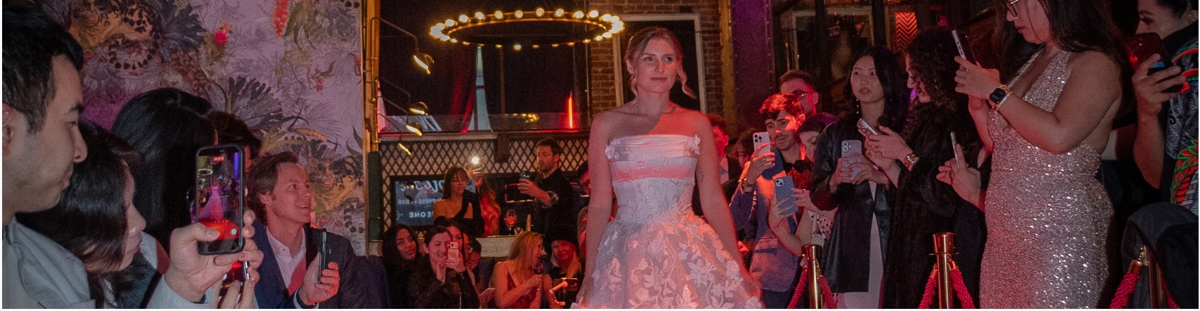 Crowd filming a bridal look on the runway at an Xchange Fashion event